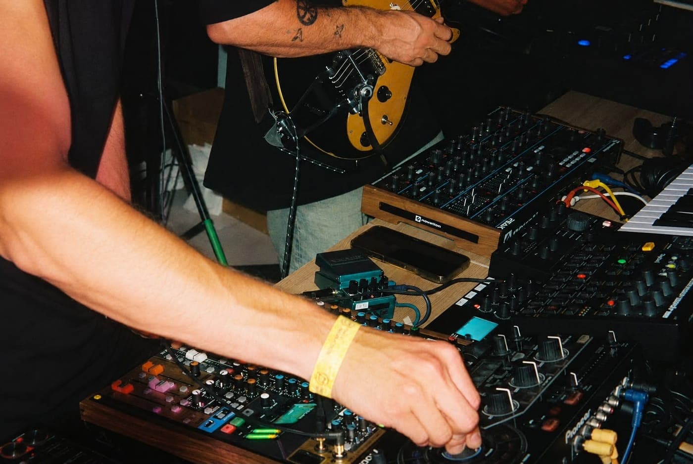 Hands on the mixer and guitar during the set