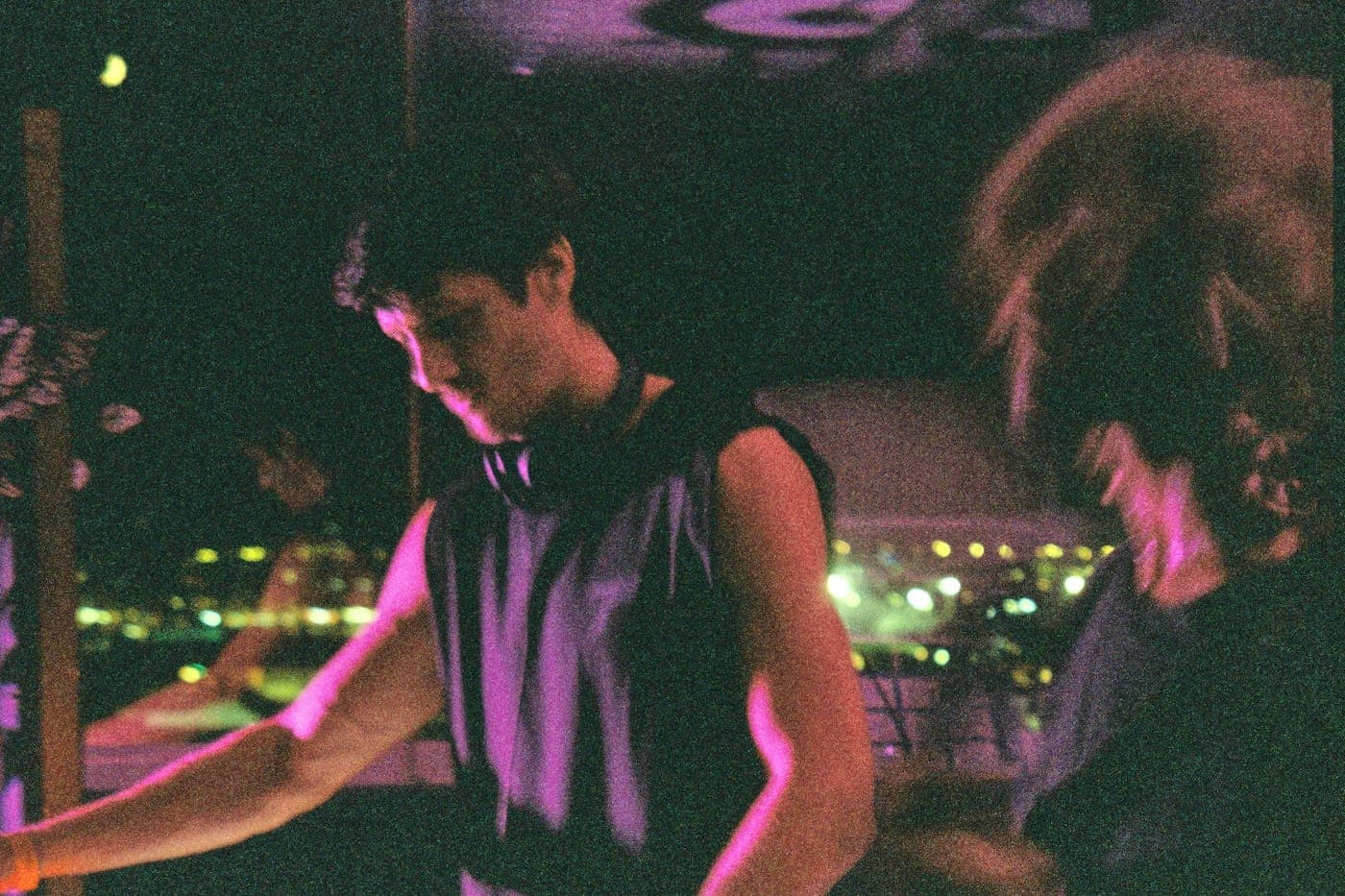 Behind the decks with the lights of Ibiza beyond the terrace